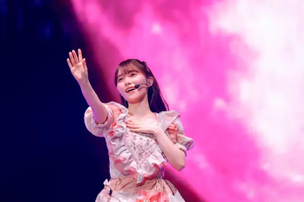 櫻坂46の守屋麗奈がピンクの衣装でライブステージに立ちパフォーマンスする様子（コンサート収入イメージ）