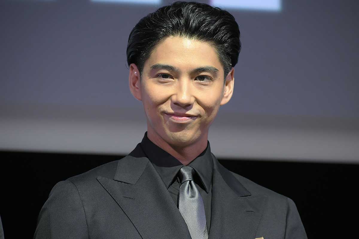 人気男性俳優のステージ登壇ショット｜ブラックスーツで微笑む作品プロモーション用アイキャッチ