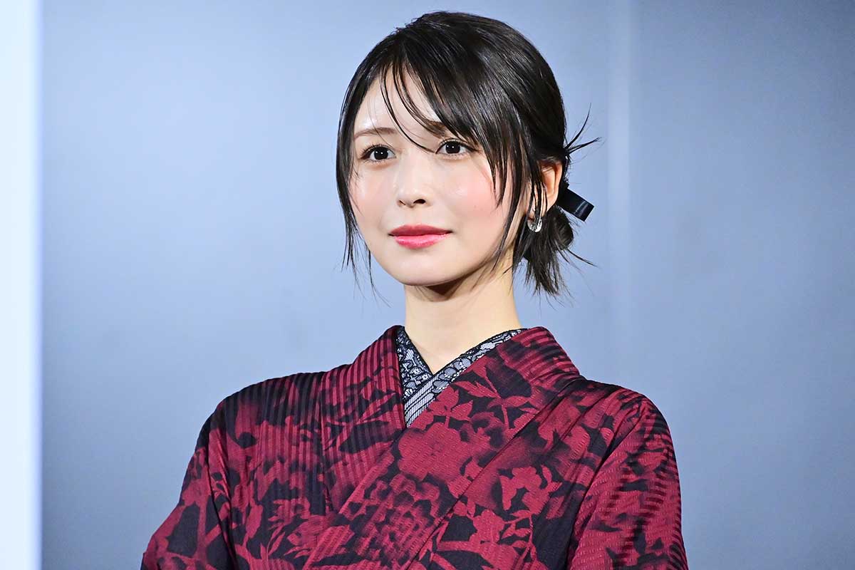 和柄の赤い着物を着た若い女性タレントが正面を向いて微笑むポートレート写真