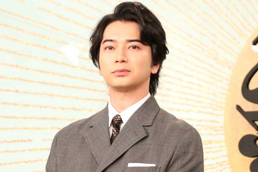 グレーのスーツを着た男性タレントが正面を見つめるバストアップ写真｜ドラマやCMで活躍する人気俳優の年収や収入源を特集する記事のアイキャッチ画像