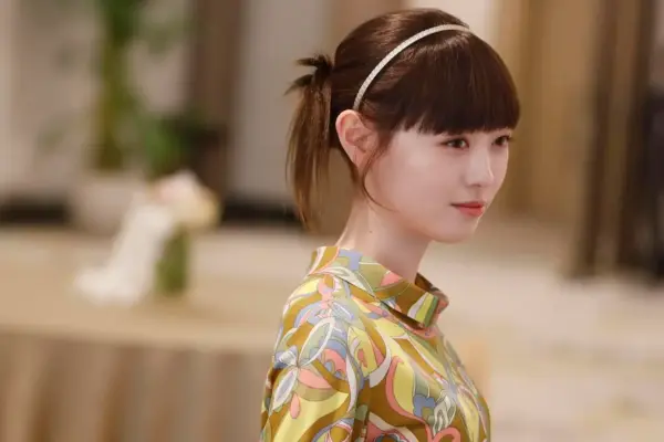 カラフルなワンピース姿で横顔を見せる福原遥のドラマシーン（パーティー会場風の上半身アップ）