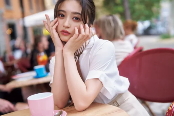 カフェの席で手を頬に当てて見つめる井上和（乃木坂46）、昨年の推定年収記事向け写真