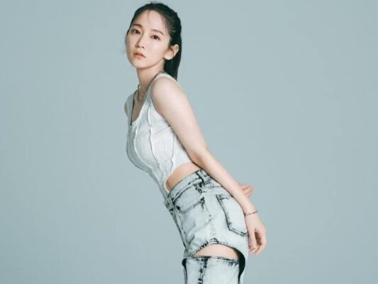 白いトップスとデニムスタイルでポーズを取る女性俳優の全身イメージカット