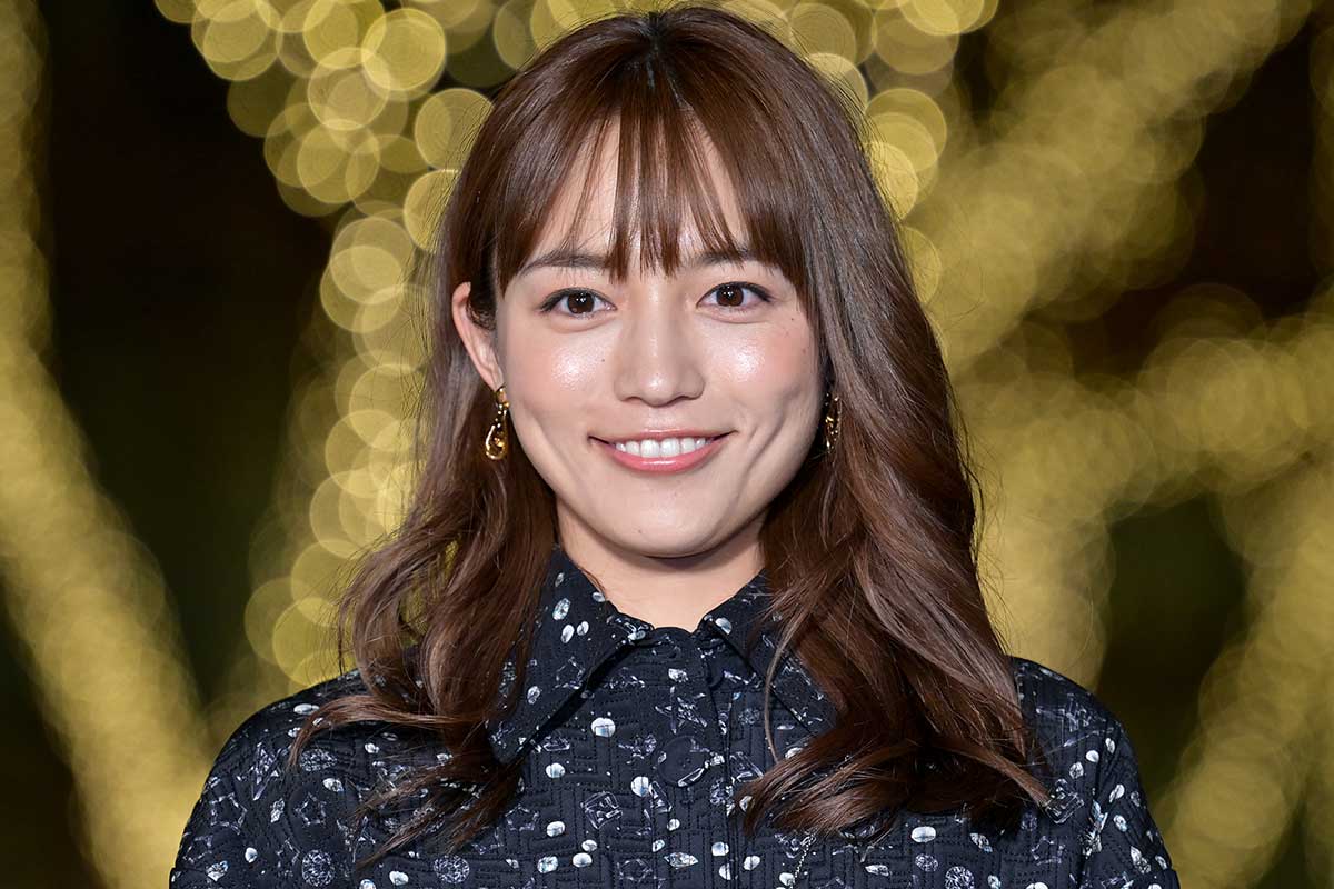 イルミネーションを背景に笑顔で立つ女性のアップ写真（川口春奈の現在の活躍と高年収をイメージしたビジュアル）