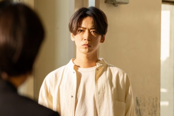 シリアスな表情の男性が室内で相手と向き合うサスペンスドラマの重要シーン