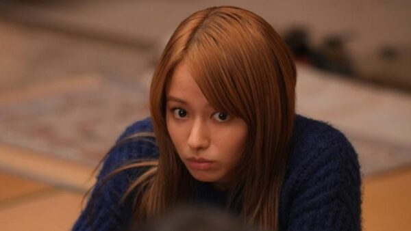 暗めの室内で真剣な表情を浮かべるロングヘアの若い女性のバストアップ・昨年の代表的なドラマ出演シーンをイメージさせる写真