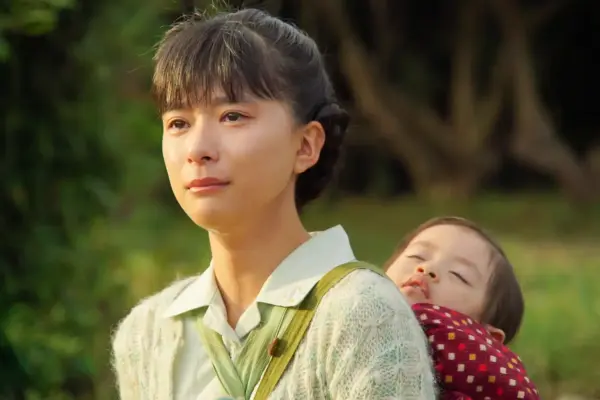 ドラマのワンシーンで涙を浮かべる芳根京子。背中には眠る赤ちゃんをおぶい、母の強さと優しさを表現している感動的な場面。