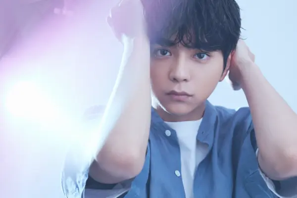 柔らかな表情の男性アイドルがライトに照らされているポートレート写真。経歴やプロフィール紹介ページに使えるメインビジュアル