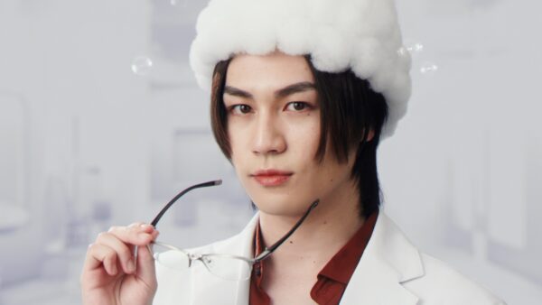 泡の帽子と白衣姿で眼鏡を手に持つTravis Japan松田元太のアップ写真 シャンプーCM風ビジュアルの年収解説用イメージ