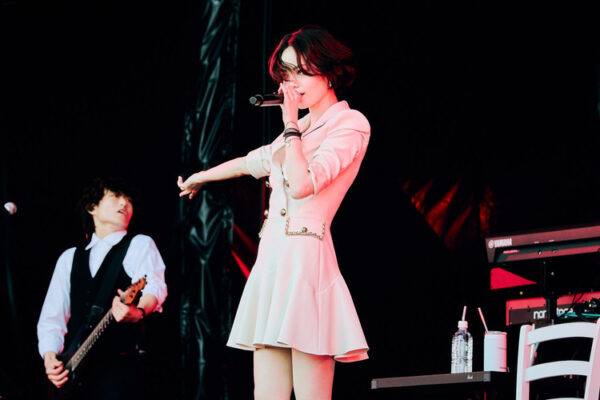 平手友梨奈が白いワンピース姿でマイクを握り、バンドを背にライブステージで熱唱する写真