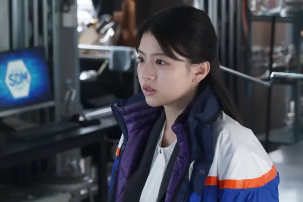 防寒ジャケット姿で真剣な表情を見せる出口夏希 ドラマ現場で演技する様子のスチール写真