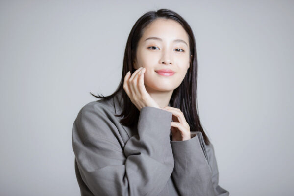 グレーのジャケット姿でほほ笑む広瀬すずの宣材風ポートレート写真（プロフィール・経歴紹介用）