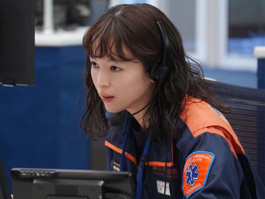 清野菜名がヘッドセットで通話対応する指令管制員の場面カット｜月9『１１９ エマージェンシーコール』勤務シーン