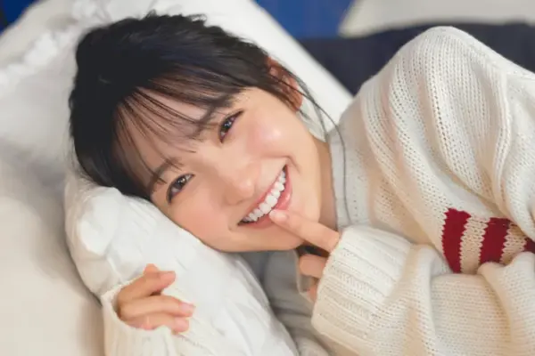 一ノ瀬美空の経歴まとめ記事のイメージ｜笑顔で横たわる女性のポートレート（乃木坂46関連）